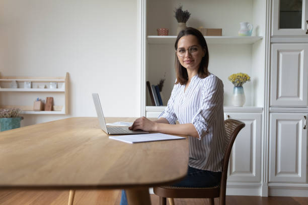 istock Businesswoman distracted from work on laptop looking at camera 1385188688