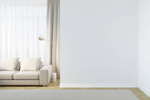 istock Bright modern room with a blank white wall, a light beige sofa and a floor lamp next to light curtains, a beige carpet on the parquet floor. Front view. 1385192937