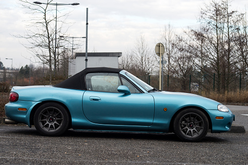 Mulhouse - France - 13 March 2022 - Profile view of blue mazda mx5 convertible parked in the street