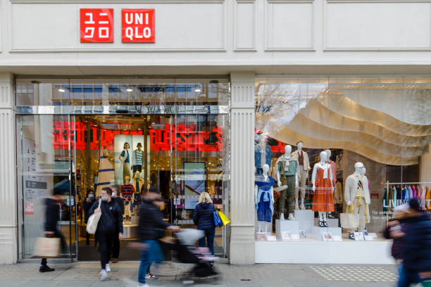 Exterior of Uniqlo clothing store with blurred motion of people on city street stock photo