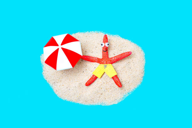 istock Starfish character under a sunshade on the beach 1385195249