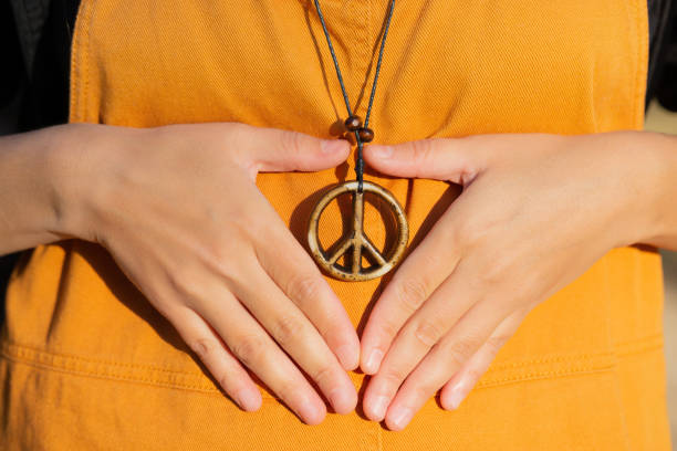 istock Making a heart shape around a peace sign necklace 1385195301