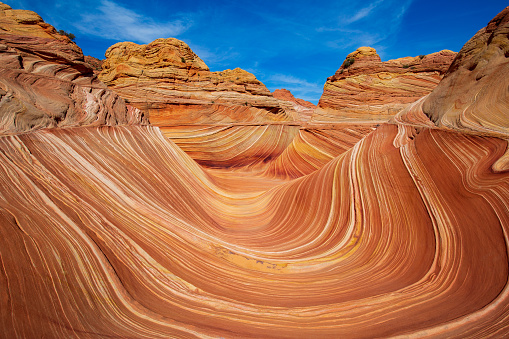 Man looks up from a crevice deep inside a slot canyon; Page; AZ; USA