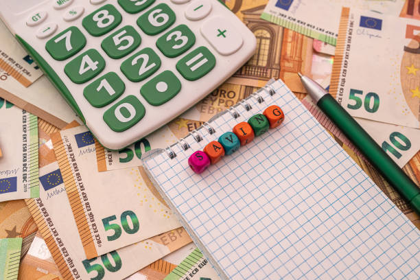 istock business notebook with pen calculator lie on background with euro banknotes. 1385197598