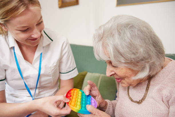 female physiotherapist getting senior woman to use fidget toy - occupational therapy imagens e fotografias de stock