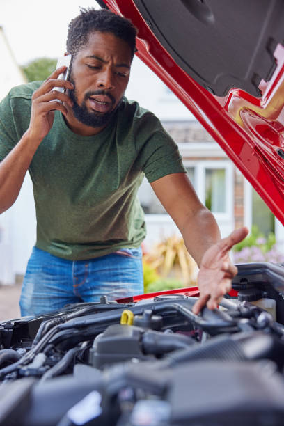 istock Man Looking At Engine After Car Breakdown Calling Auto Recovery On Mobile Phone 1385198223