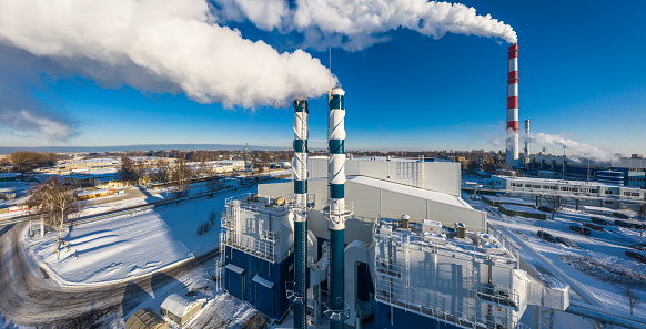 Riga, Latvia - December 8, 2021: Modern high power biofuel boiler house. A gas-fired power plant is visible in the background. Drone photography