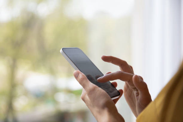 istock Closeup cropped view woman holds modern smartphone share text messages 1385199019