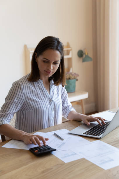 istock Housewife check household bills, calculates utilities, pay through e-bank 1385199020