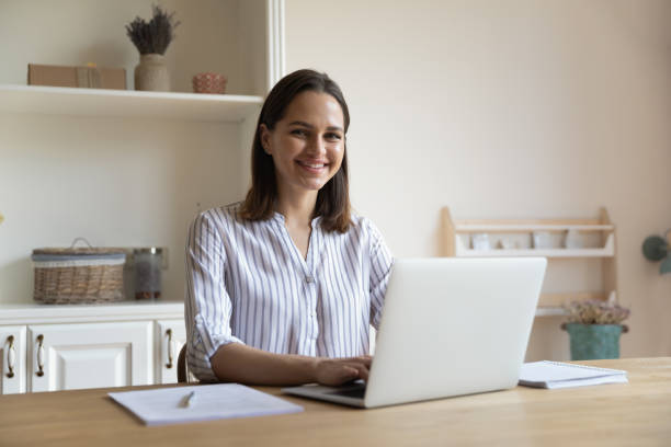 istock Woman distracted from work on laptop smile look at camera 1385199028