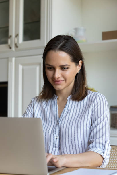 istock Woman sit at table smile working on laptop from homeoffice 1385199032