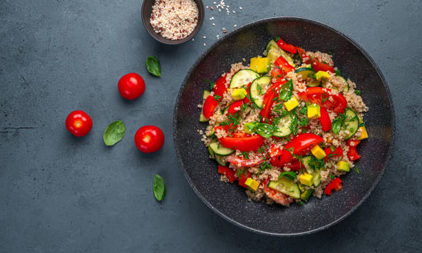 istock Vegetarian healthy salad with quinoa, vegetables and fresh herbs on a graphite background 1385200686