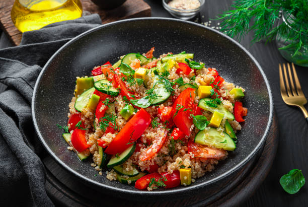 istock Salad with quinoa, avocado, tomato and cucumber on a dark background 1385201259