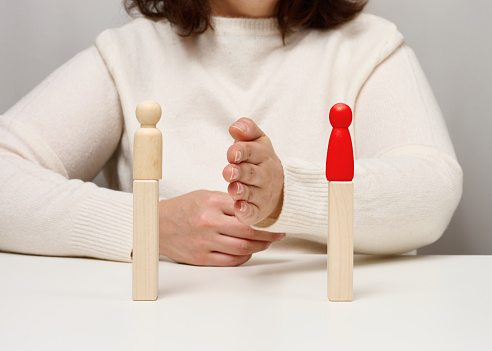 two wooden figurines of a man stand opposite each other, concept of reconciliation of opponents, the end of bullying, the search for a compromise
