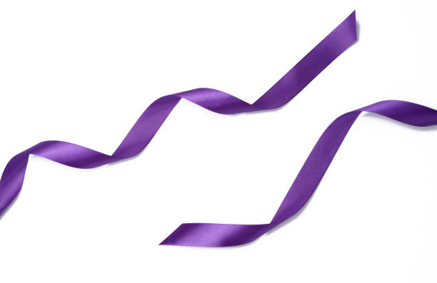 istock swirling purple silk ribbon on white background, gift wrapping decor. Top view 1385203416