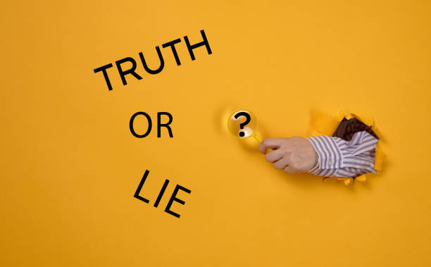 istock hand holds a magnifying glass, the inscription on a yellow background true or false. The concept of the search for truth, the manipulation of the masses 1385203666
