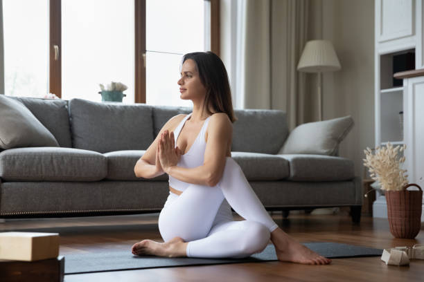 istock Young sporty woman perform Ardha Matsyendrasana practicing yoga at home 1385203842