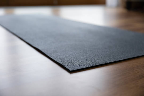 istock Empty black rubber yoga mat on floor, no people 1385203878