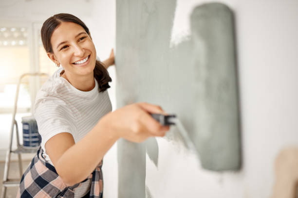 scatto di una bella giovane donna che dipinge un muro a casa - painting foto e immagini stock