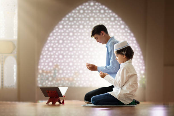 ramadã kareem saudando. pai e filho na mesquita. - saudi arabia child ramadan offspring - fotografias e filmes do acervo