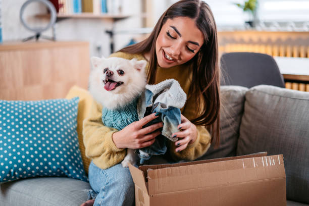 istock Young Woman Unpacking A Package For Her Dog 1385209673