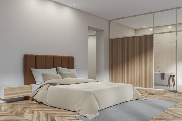 istock Bright bedroom and bathroom interior with bed, bathtub, glass partition 1385210997