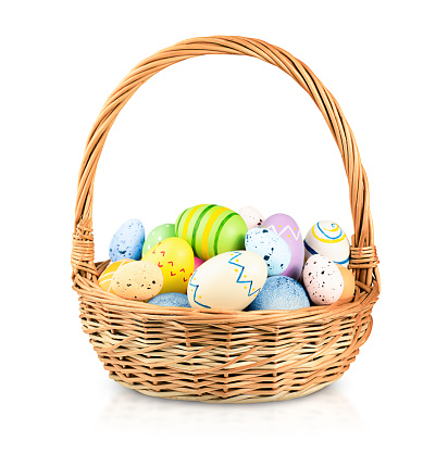wicker basket with easter eggs on a white isolated background