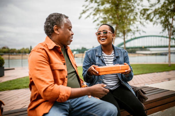 istock Young woman opening present from her father 1385226294