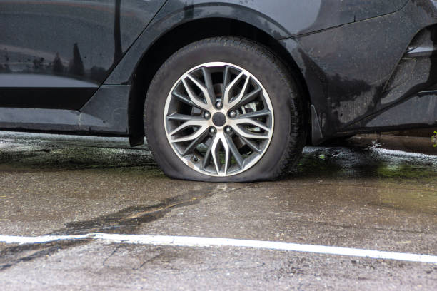 istock a car with a flat tire stands on asphalt wet from the rain 1385229447