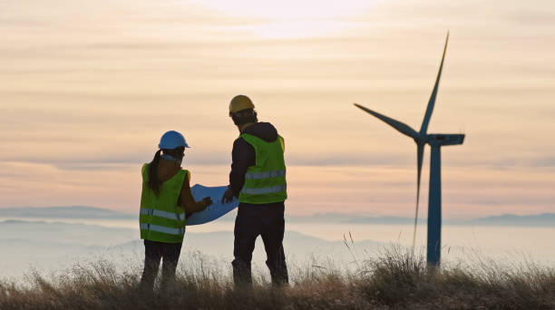 istock Wind energy engineers working in wind farm at dusk. Renewable Energy Systems. Carbon neutrality and sustainable energy. 1385234928