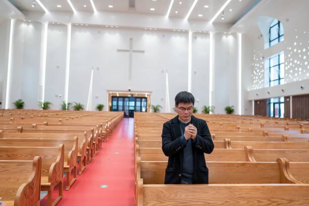 An Asian man prayed in church.