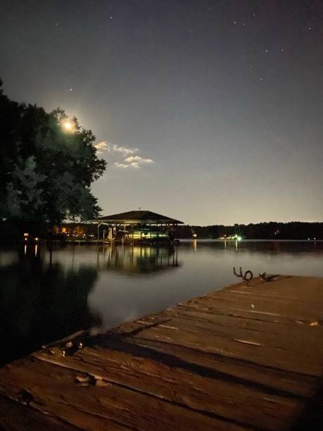 istock Full moon with stars at night over a dock on the lake 1385242430