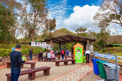Laguna de Guatavita, Colombia - August 14, 2021: People waiting to enter the park at the Laguna. Due to Covid-19 regulations everyone is wearing a face mask.