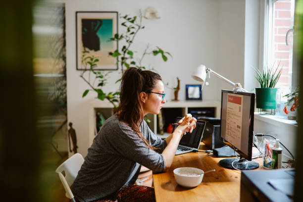 frau, die ihre online-flugtickets zu hause überprüft - telecommuting stock-fotos und bilder