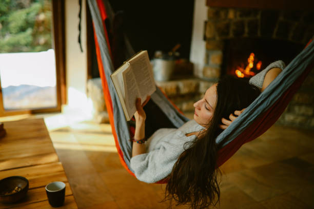 istock woman reading a book while relaxing in the hammock 1385274851