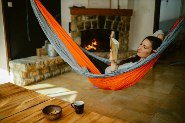 istock woman reading a book while relaxing in the hammock 1385274897
