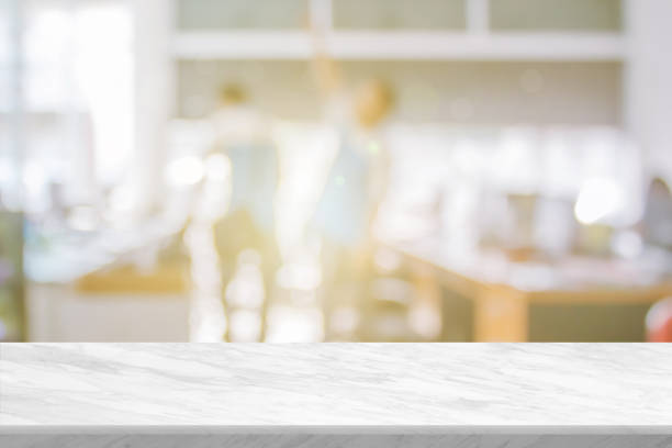 istock White stone marble table top and blurred building office abstract background. Interior banner show with desk backdrop counter blur work people in workplace can used for display or your products. 1385277207