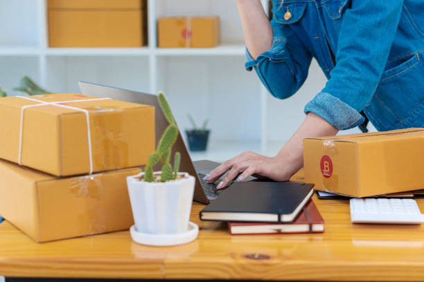istock work at home. sell products online A small business owner just getting started with laptop computers at his desk and mailboxes in his room SME owners in Asia. 1385277331