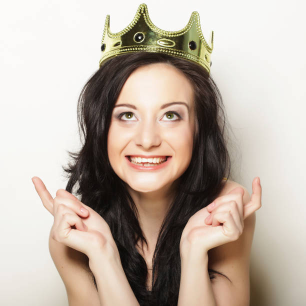 istock pretty brunette woman wearing crown 1385278230