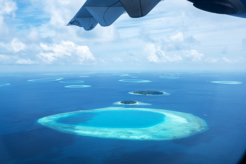 Aerial view tropical island and atolls from aircraft windows