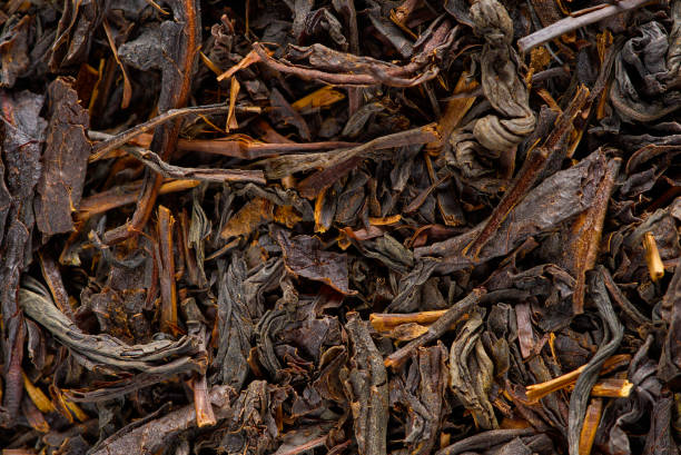 istock Black large-leaf tea as abstract background. Texture of dry black tea leaves. Dark background 1385280018