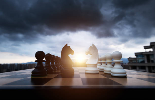istock Two chess knights battle on city background 1385299414