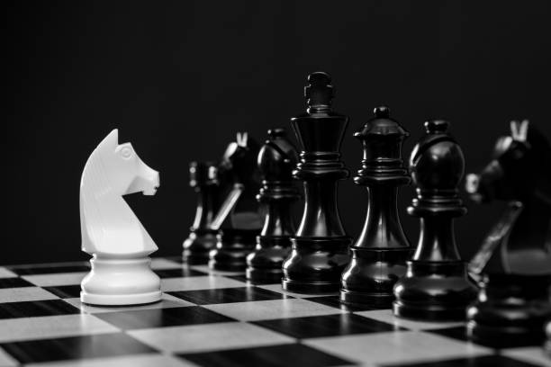 istock White knight and black chess pieces on chess board 1385299961