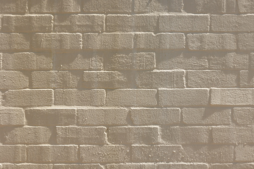 Close-up on an old beige brick wall.