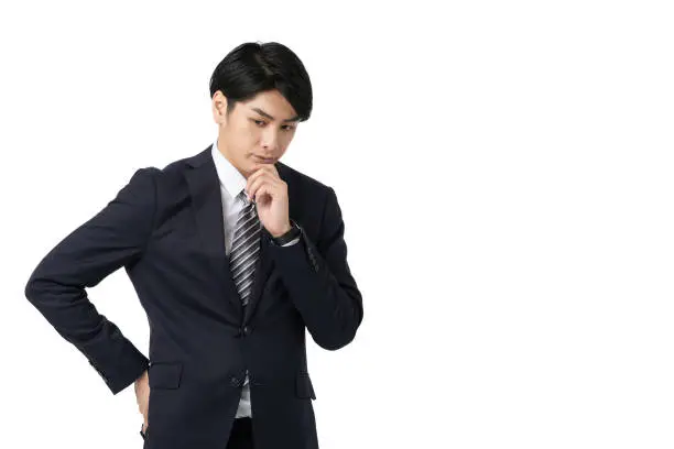 Asian businessman thinking with his arms crossed