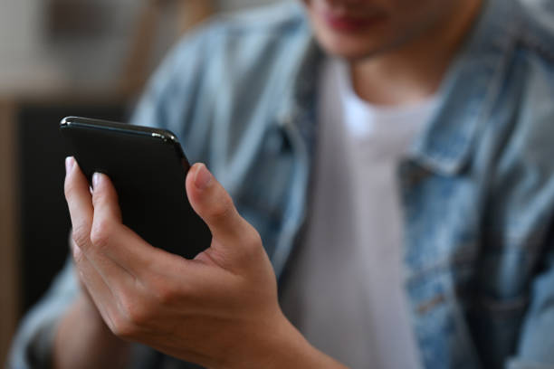 istock Close up image of male typing text message on smartphone. 1385314553