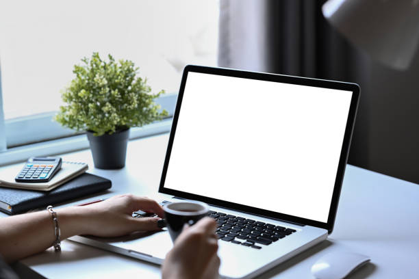 istock Woman holding coffee cup and working online, checking email on computer laptop. 1385314571