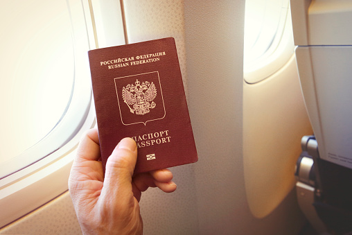 Passenger holding Russian passport on the airplane