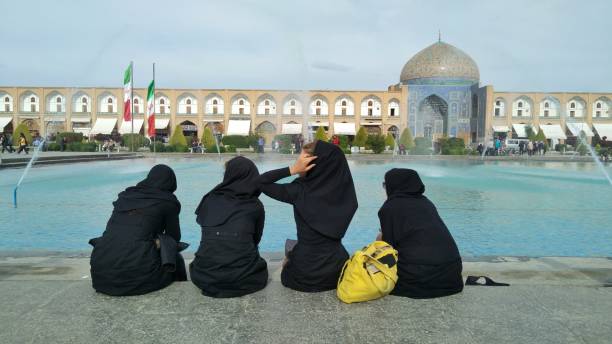 Four ladies sitting on the pool side in Isfahan Imam Square Imam Square in Isfahan is one of the most popular travel destinations in Iran, and it's one of the biggest in the world. iranian culture stock pictures, royalty-free photos & images
