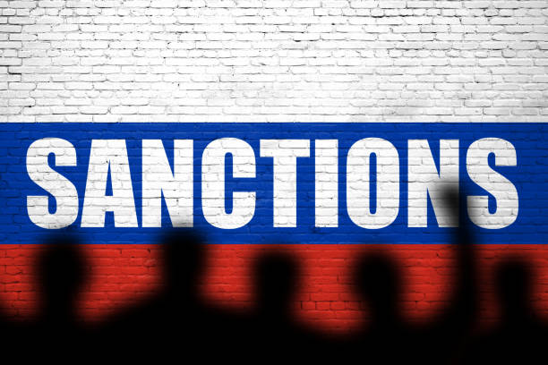 istock Flag of Russia painted on a brick wall with word sanctions 1385316906
